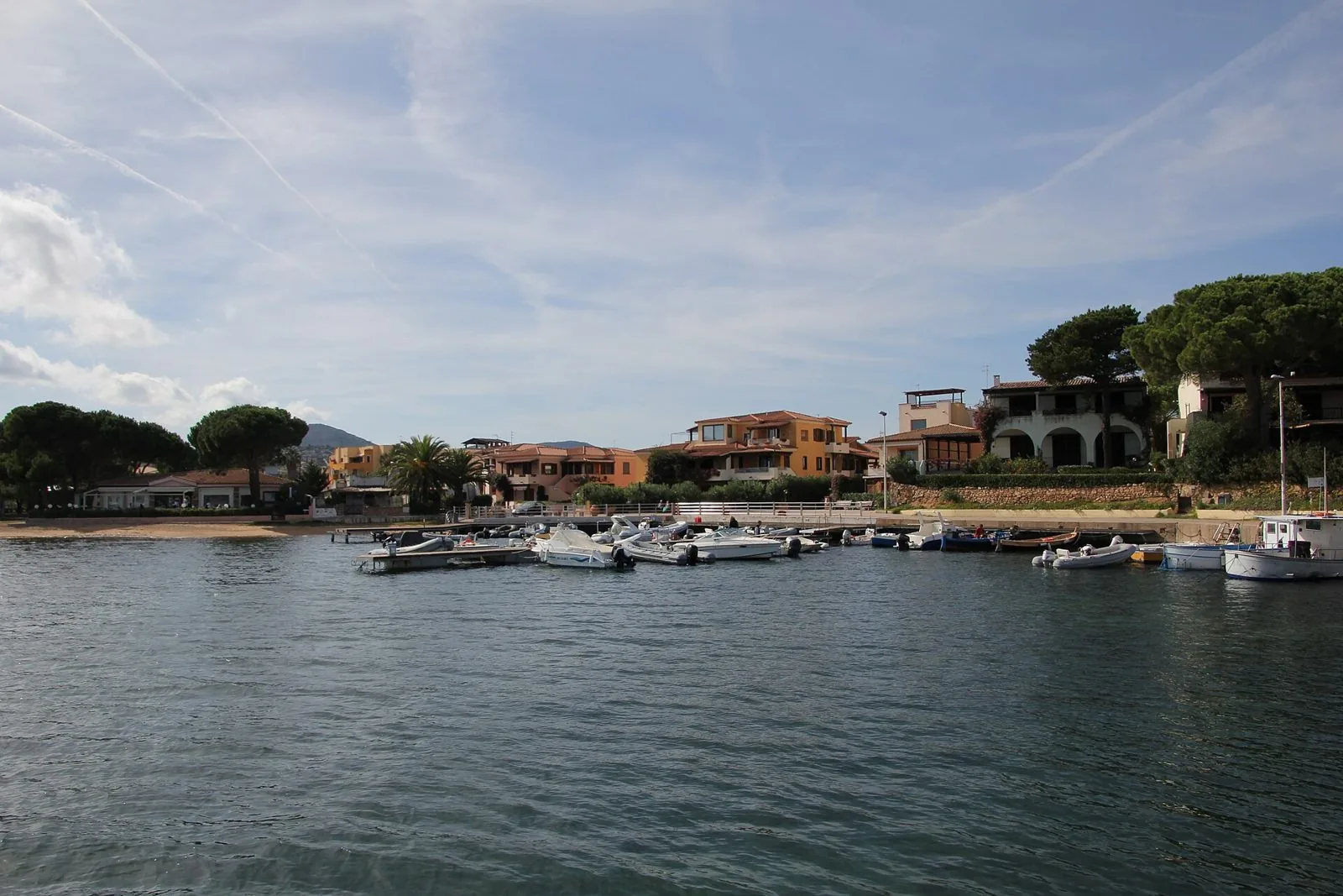 Barche e gommoni ormeggiati al pontile di Porto San Paolo, in Gallura, con le case affacciate sul mare